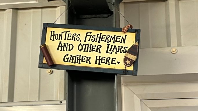 Sign stating "Hunters, Fishermen and Other Licenses Gather Here."